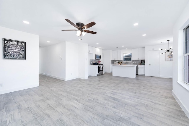 unfurnished living room featuring ceiling fan and light wood-type flooring