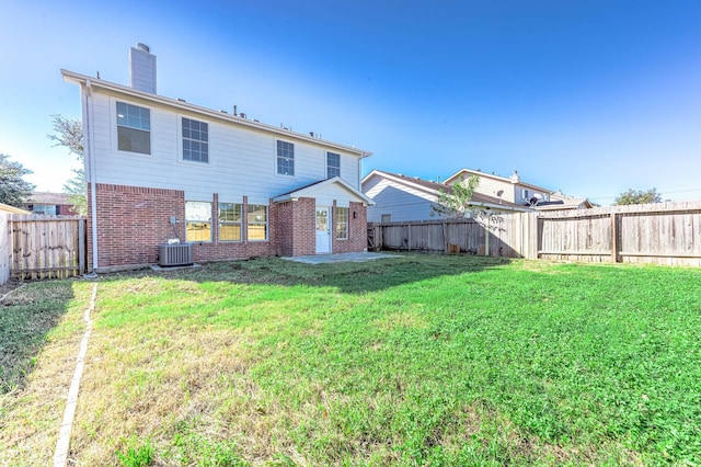 rear view of property with a lawn, a patio area, and cooling unit