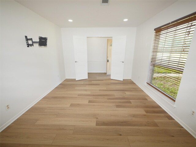 hall featuring plenty of natural light and light hardwood / wood-style flooring