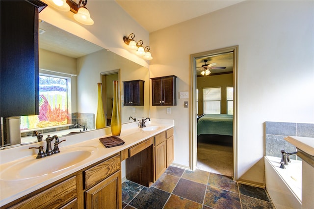 bathroom with ceiling fan, vanity, and a bathtub