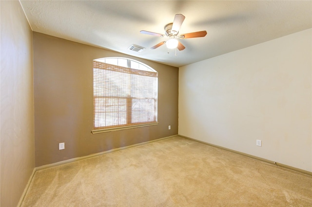 empty room with ceiling fan and light colored carpet