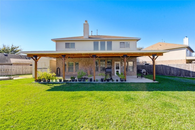 back of house featuring a patio area and a lawn