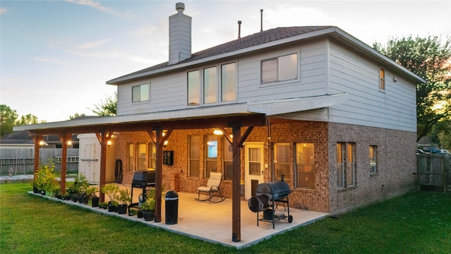 back of house featuring a storage shed, a lawn, and a patio