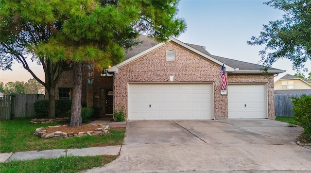 view of front facade with brick siding, an attached garage, and fence