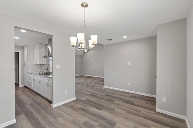 kitchen featuring decorative backsplash, light stone counters, decorative light fixtures, a chandelier, and white cabinetry