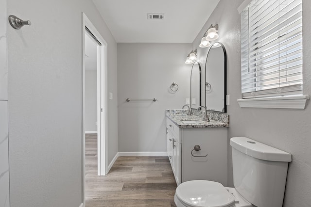 bathroom featuring hardwood / wood-style floors, vanity, and toilet