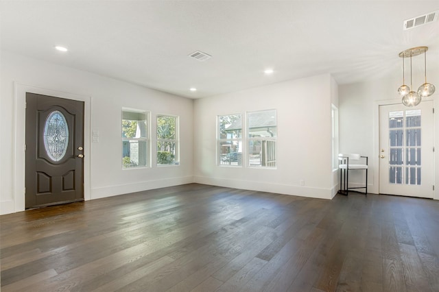 entrance foyer featuring an inviting chandelier and dark wood-type flooring