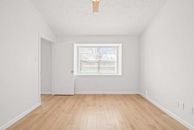 empty room featuring a textured ceiling and light hardwood / wood-style flooring