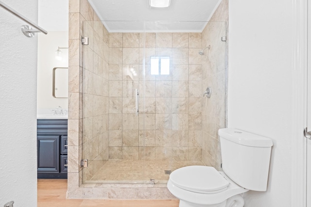 bathroom featuring toilet, a shower with door, vanity, and wood-type flooring