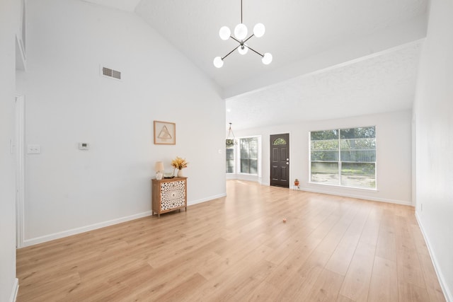 unfurnished living room featuring high vaulted ceiling, a notable chandelier, and light hardwood / wood-style flooring