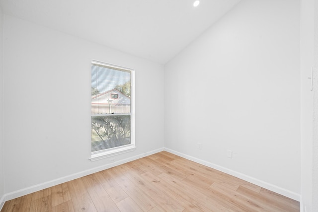 unfurnished room featuring lofted ceiling and light hardwood / wood-style floors