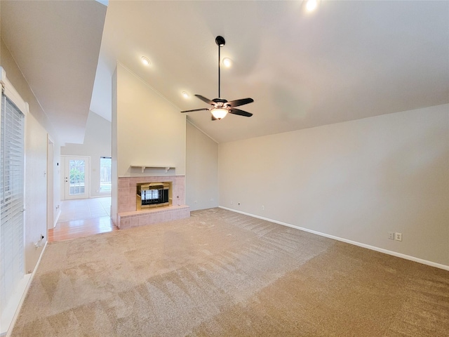 unfurnished living room featuring carpet, high vaulted ceiling, ceiling fan, and a tiled fireplace