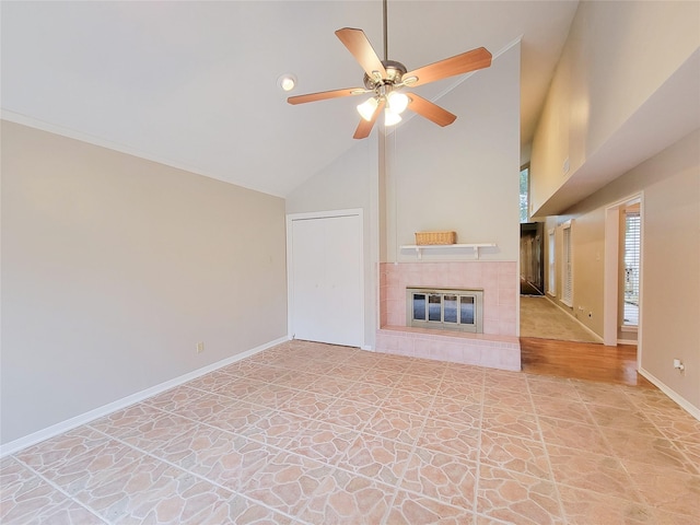 unfurnished living room with a tile fireplace, ceiling fan, and high vaulted ceiling