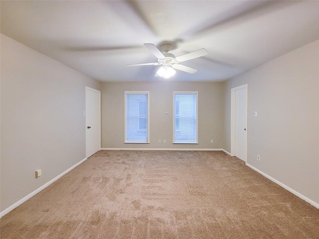 empty room with ceiling fan and light carpet