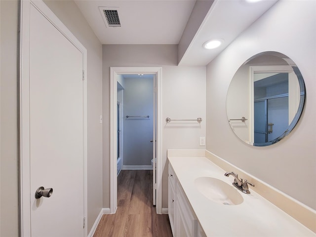 bathroom with a shower, hardwood / wood-style floors, vanity, and toilet