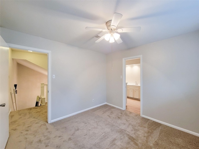 empty room featuring light carpet, ceiling fan, and sink