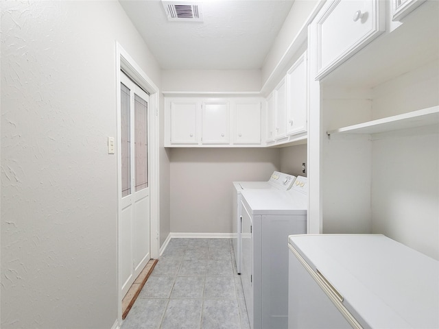 laundry room featuring cabinets and washing machine and clothes dryer