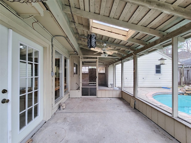 unfurnished sunroom featuring a wealth of natural light, ceiling fan, wooden ceiling, and lofted ceiling with skylight