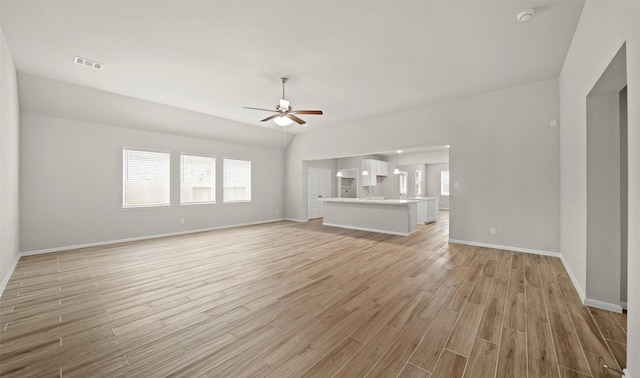 unfurnished living room with light hardwood / wood-style flooring, ceiling fan, and vaulted ceiling