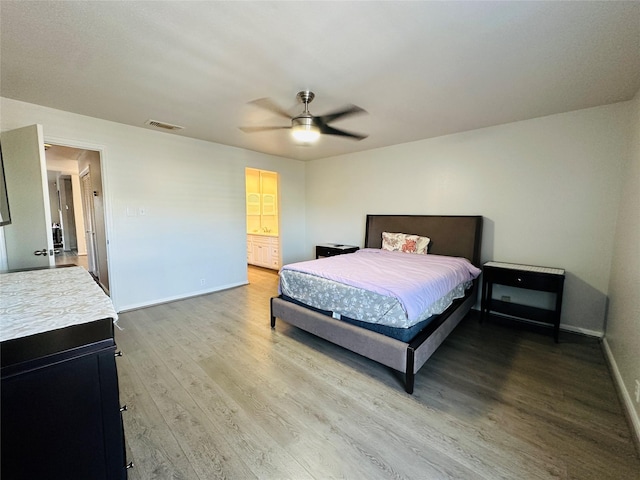 bedroom with hardwood / wood-style floors, ensuite bathroom, and ceiling fan