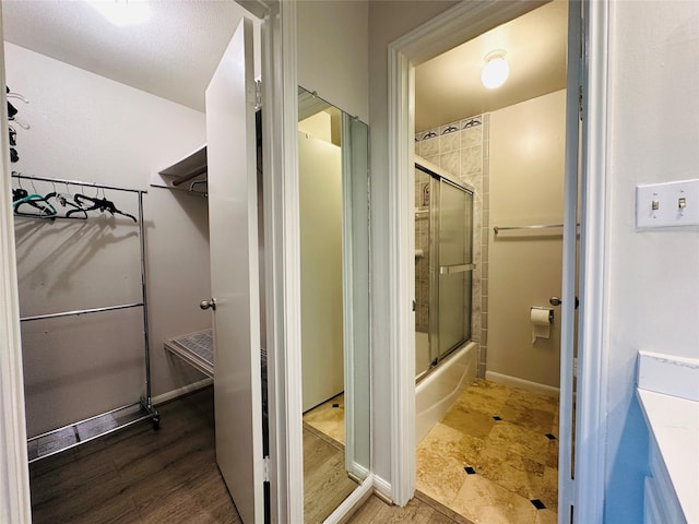 bathroom featuring hardwood / wood-style floors and enclosed tub / shower combo