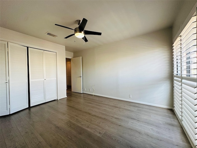 unfurnished bedroom featuring a closet, ceiling fan, and dark hardwood / wood-style flooring