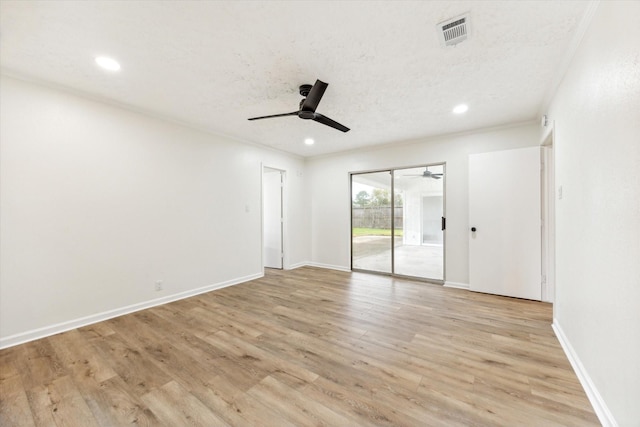 spare room featuring a textured ceiling and light hardwood / wood-style flooring