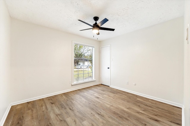 empty room featuring ceiling fan, light hardwood / wood-style flooring, and a textured ceiling