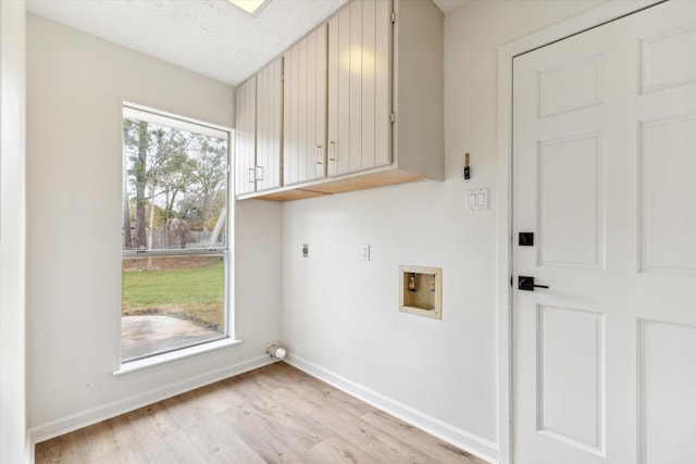 laundry area with electric dryer hookup, hookup for a washing machine, plenty of natural light, and cabinets