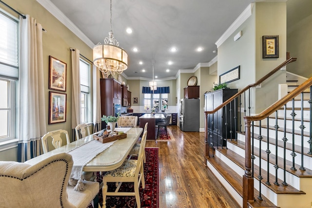 dining space with dark hardwood / wood-style flooring, ornamental molding, and a notable chandelier