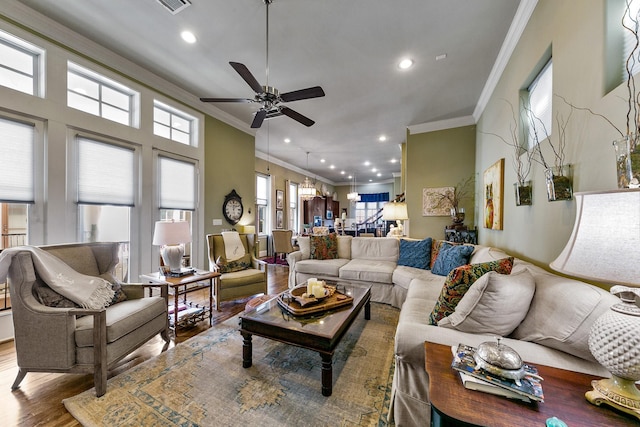 living room featuring ornamental molding, ceiling fan, and wood-type flooring