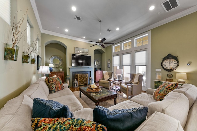 living room with ornamental molding and ceiling fan