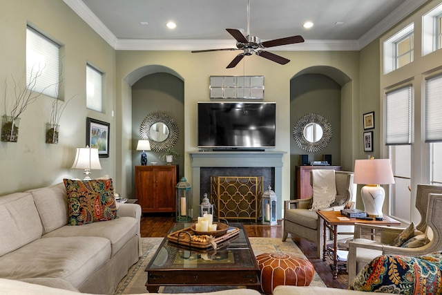 living room featuring dark wood-type flooring, ceiling fan, and crown molding