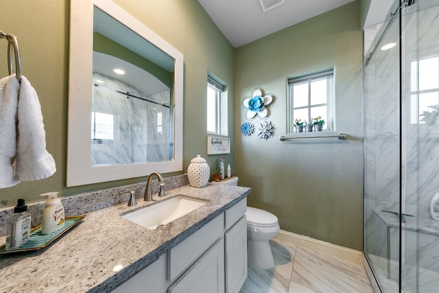 bathroom with vanity, a shower with shower door, and toilet