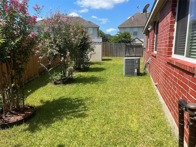 view of yard featuring a storage unit and central air condition unit