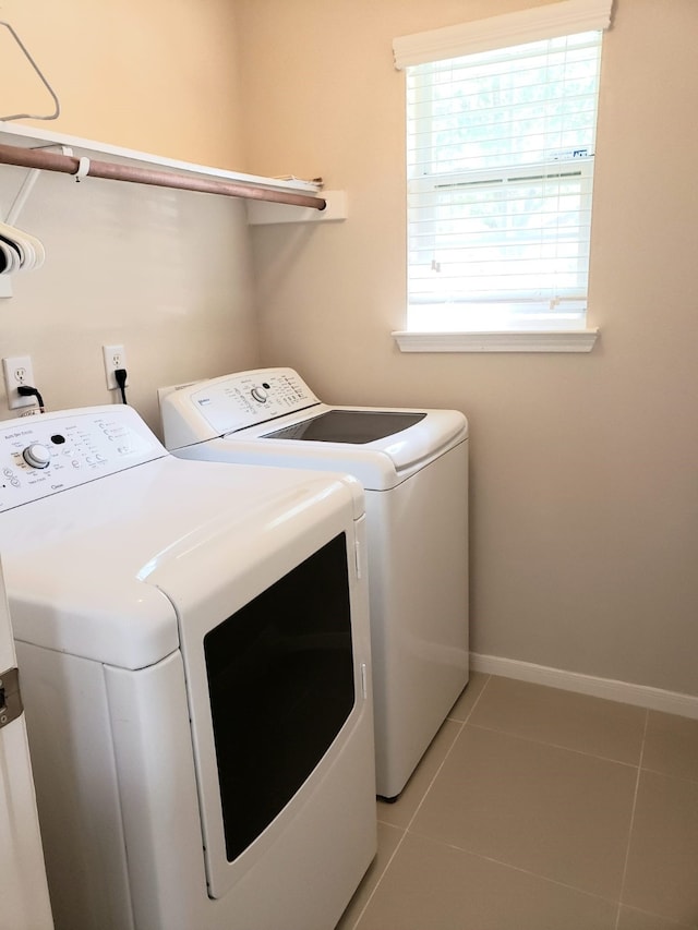 laundry room featuring washing machine and dryer and light tile patterned floors