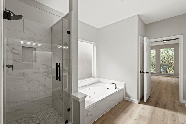 bathroom featuring plus walk in shower and hardwood / wood-style floors