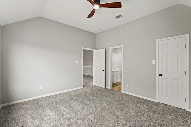 unfurnished bedroom with ceiling fan, carpet, ensuite bathroom, and lofted ceiling