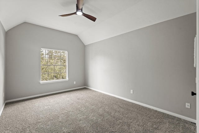 carpeted spare room featuring ceiling fan and vaulted ceiling