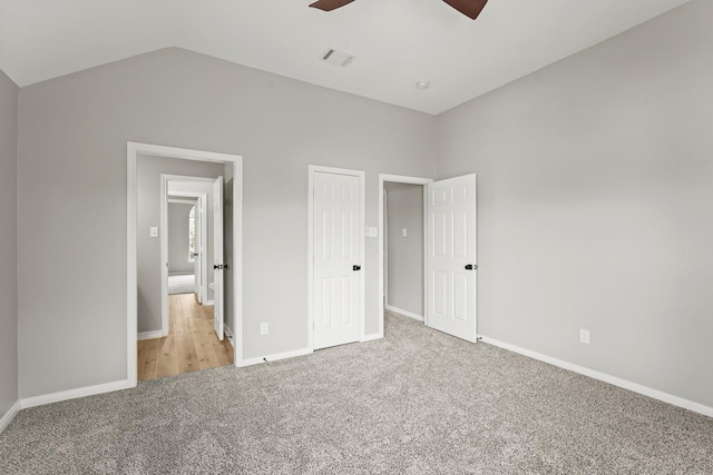 unfurnished bedroom with ceiling fan, light colored carpet, and vaulted ceiling