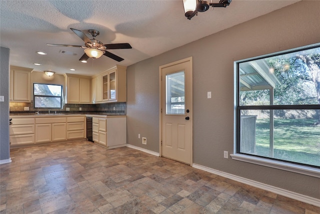 kitchen with backsplash, a textured ceiling, ceiling fan, beverage cooler, and sink