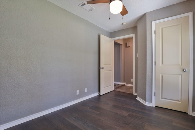 unfurnished bedroom with a textured ceiling, ceiling fan, and dark hardwood / wood-style floors