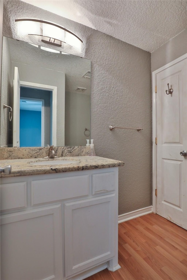 bathroom featuring a textured ceiling, vanity, and hardwood / wood-style flooring