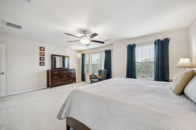 carpeted bedroom with ceiling fan and multiple windows