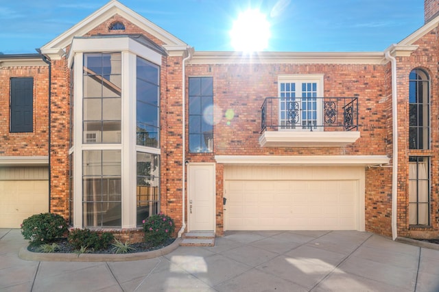 townhome / multi-family property featuring a balcony and a garage