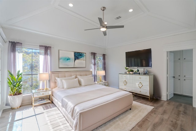 bedroom with hardwood / wood-style flooring, vaulted ceiling, ceiling fan, and crown molding