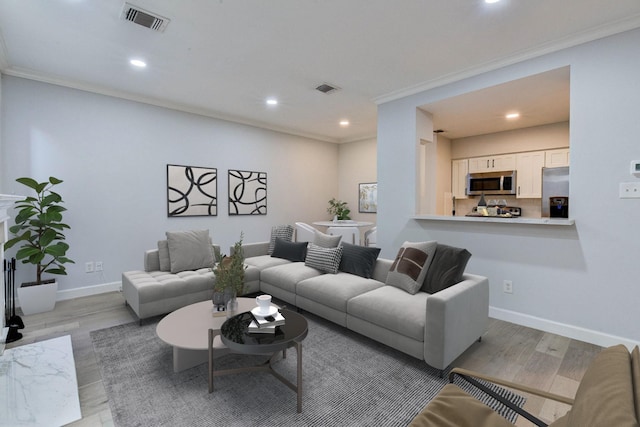 living room featuring ornamental molding and light wood-type flooring