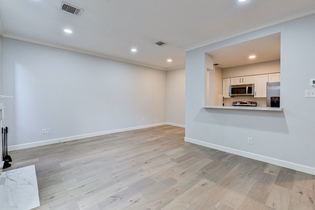 unfurnished living room featuring light hardwood / wood-style floors and crown molding