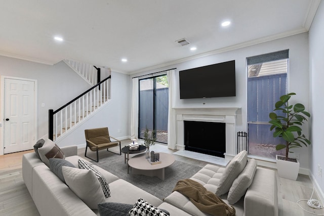 living room with light wood-type flooring and ornamental molding