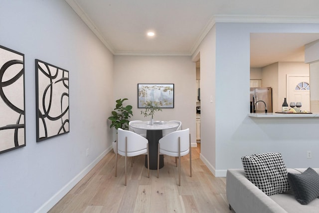 dining room with light hardwood / wood-style floors and ornamental molding